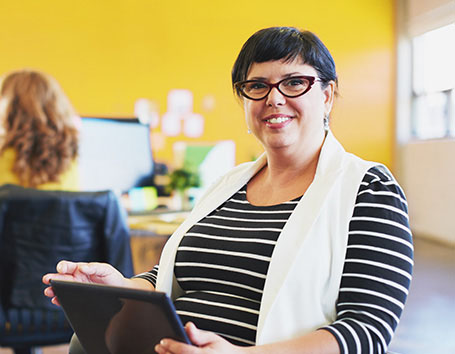 Smiling lady teacher on an iPad